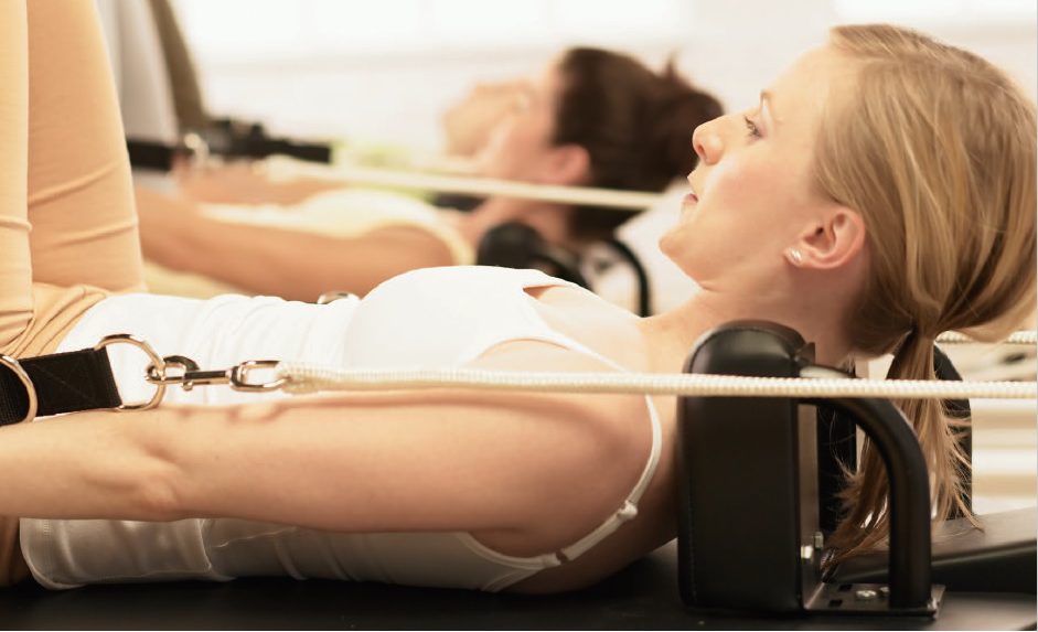 a group of people performing an exercise on Pilates Reformer
