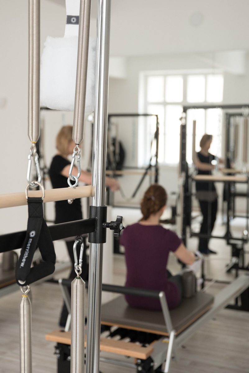 a Pilates instructor teaching an exercise on Reformer