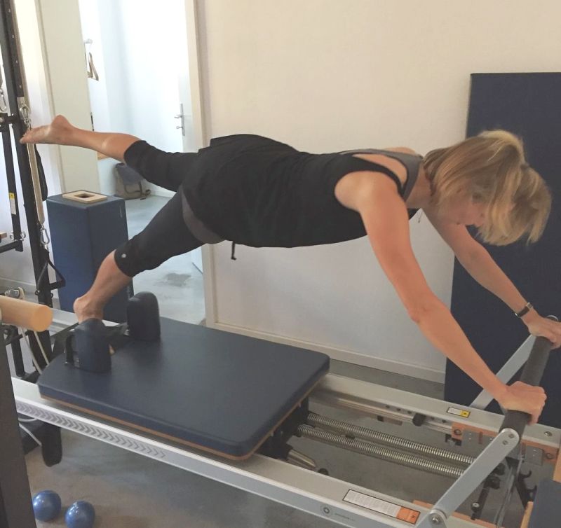 Pilates Instructor performing Push Up exercise on Reformer