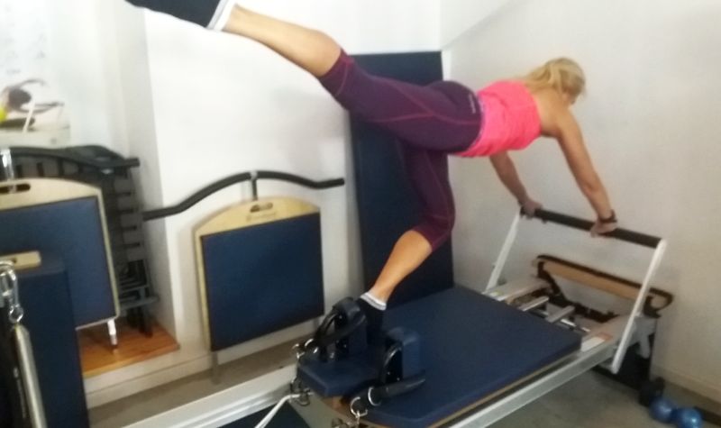 STOTT Pilates Instructor Trainer demonstrating Knee Stretches Single Leg exercise on Reformer