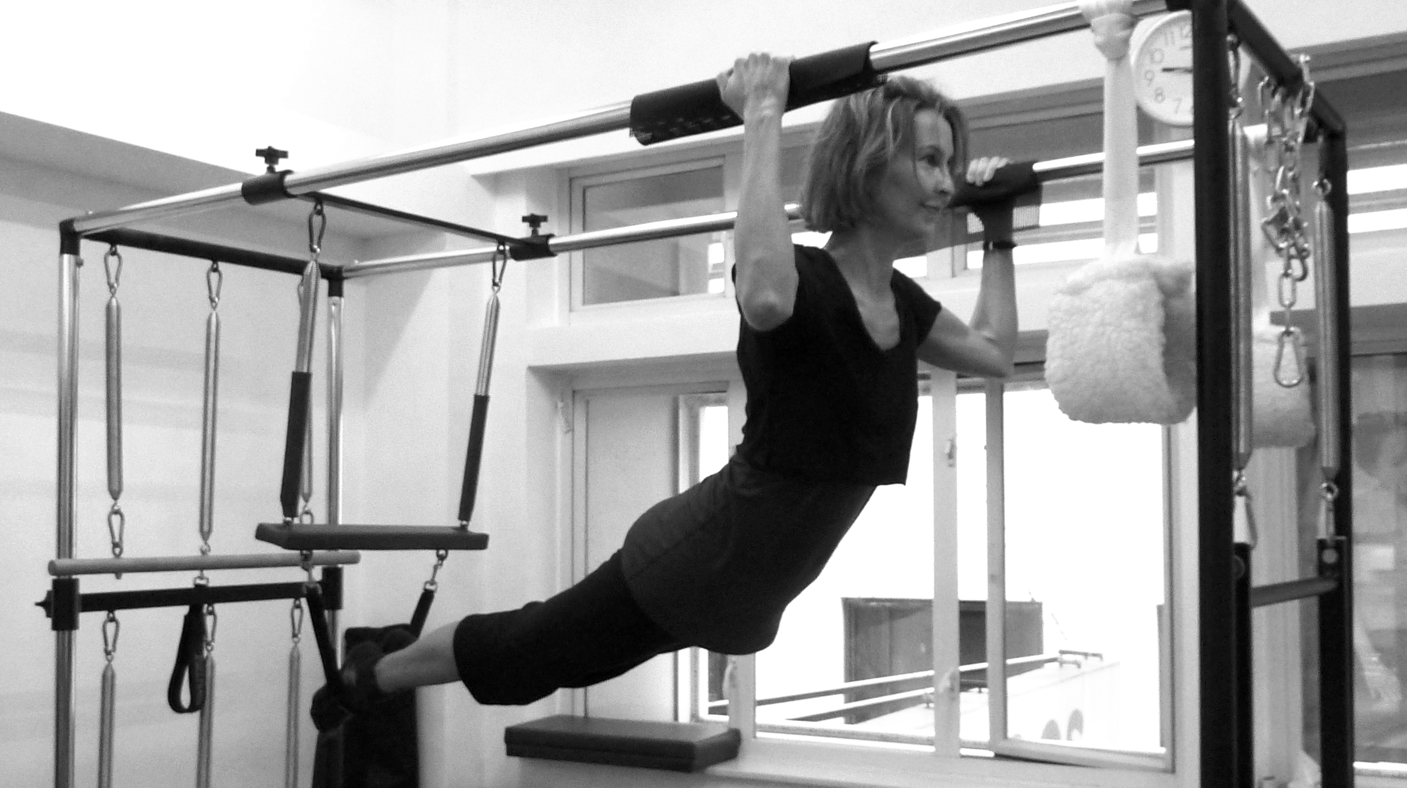 Pilates instructor demonstrating Biceps Pull Up on Cadillac